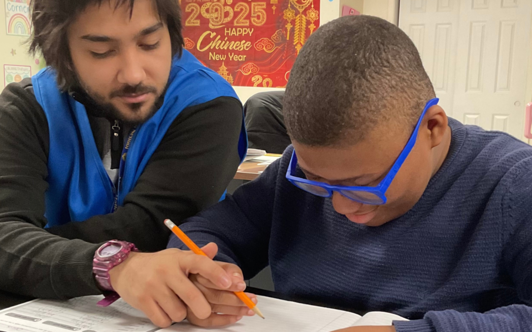 A teacher and a student reviewing an Individualized Education Plan (IEP) in a supportive classroom setting.